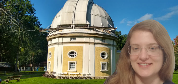 a photograph of an old observatory dome building in white and yellow with green grass around it and a blue sky, to the right a blonde woman with long hair and glasses